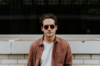 man standing in front of white concrete wall