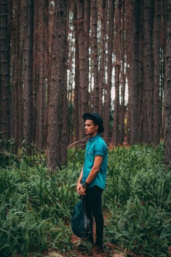 man standing in the middle of forest during daytime