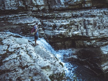 Man Standing in Waterfalls