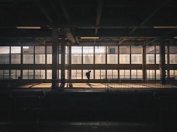 man standing inside building near window