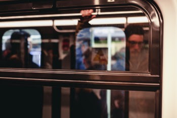 Man Standing Inside Train Waiting to Stop