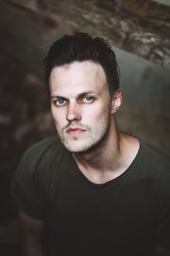 man standing near brown wall