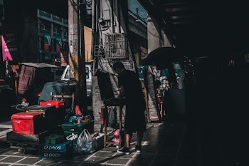 man standing near building and Pepsi bottle crates