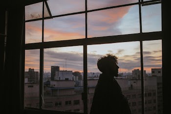 Man Standing Near Glass Window Inside Building