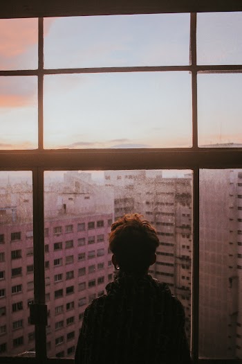 Man Standing Near Glass Window Looking Outside