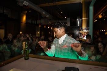 Man Standing Near Green Glass Bottle