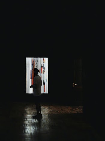Man Standing Near Lighted Wall