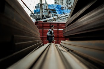 Man Standing Near Metal Fence