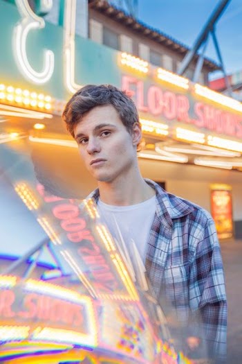 man standing near neon signage