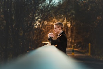 Man standing near on a bridge near trees