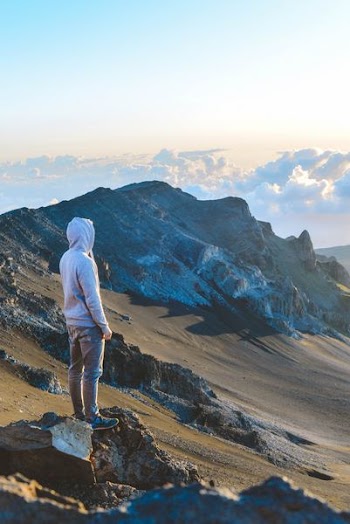 man standing near on mountain under clear blue sky during daytime