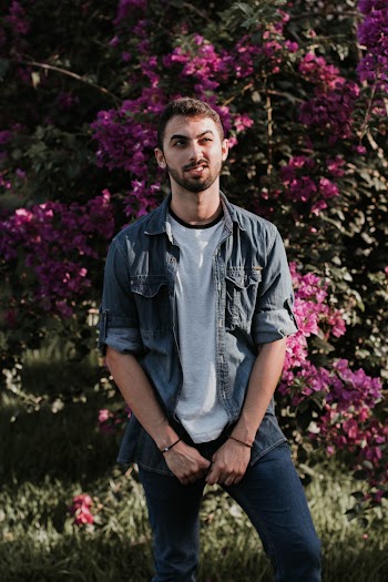Man Standing Near Pink Petaled Flower