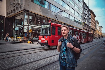 Man Standing Near Red Tram