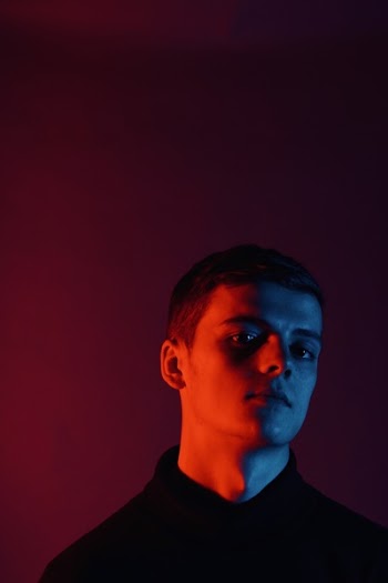 Man Standing Near Red Wall