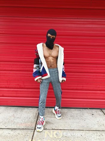 man standing near red wall