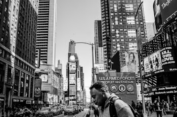 Man Standing Near Road Surrounded With High Rise Buildings
