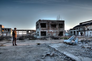 Man Standing Near Ruined Buildings 