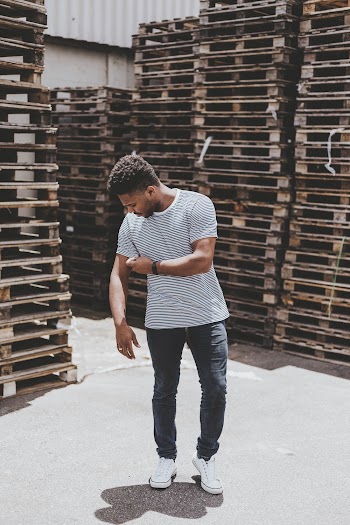 Man Standing Near Stack of Pallets