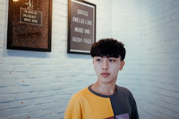 Man Standing Near Wall Leaning on His Left
