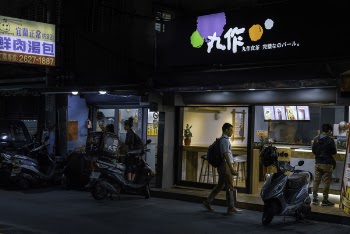 Man Standing Near White Motor Scooter at Night