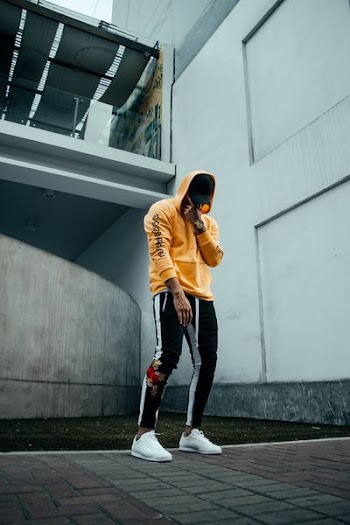 man standing near white painted wall