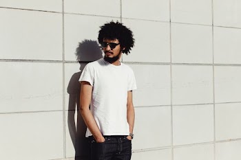 man standing near white wall during daytime