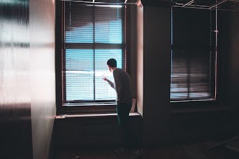 man standing near window inside building