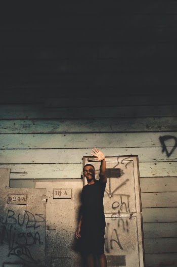 Man Standing Near Wooden Wall While Raising His Arm