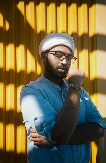 Man Standing Near Yellow Wall Wearing Eyeglasses