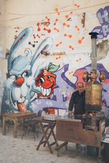 Man Standing next to a wall with Bunny and Dog Graffiti