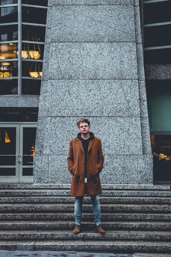 man standing next to stairs and building