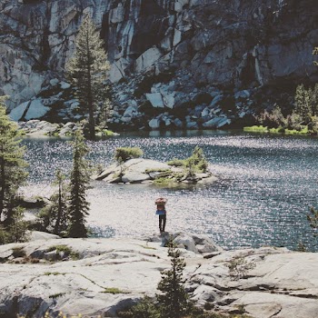 Man Standing On A Rock Near Body Of Water