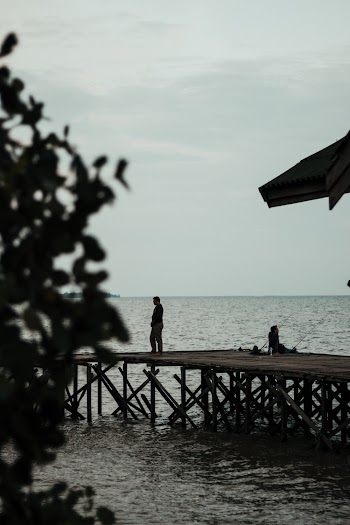 Man Standing On Boardwalk