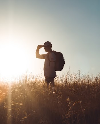 Man Standing on Brown Grass Field