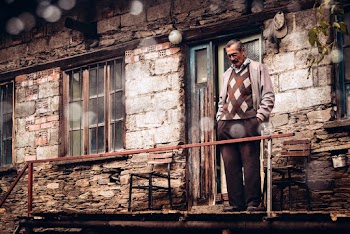 Man Standing on Brown House Balcony