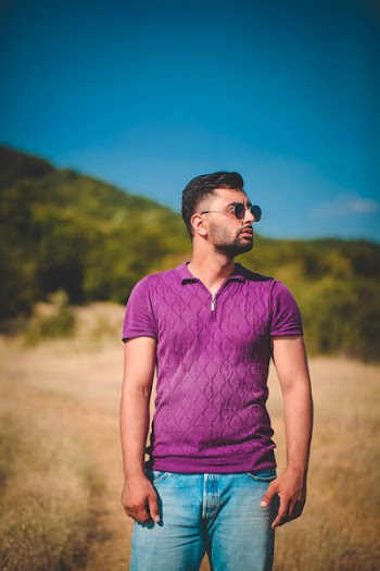 Man Standing on Brown Pathway Surrounded by Grass While Looking at Left Side