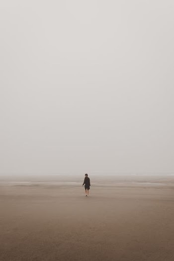 man standing on brown sand