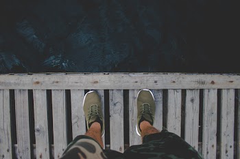 Man Standing on Brown Wooden Dock