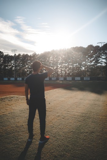 Man Standing on Field Looking on Trees