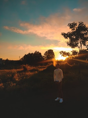 Man Standing On Grass During Golden Hour