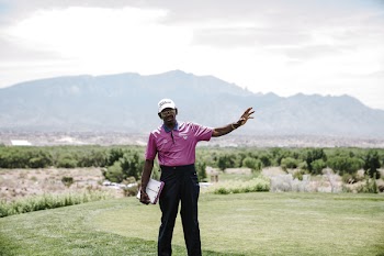 Man Standing on Grass While Raising His Left Arm