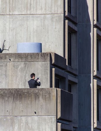 man standing on gray concrete building \