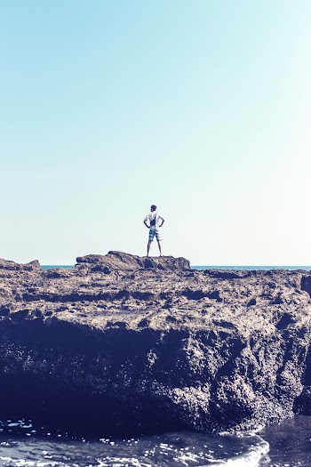 Man Standing on Grey Rock