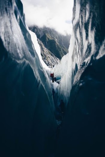 man standing on mountain cliff during daytime