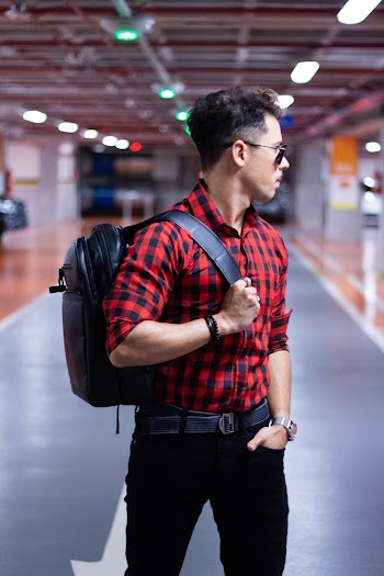 Man Standing on Parking Lot and Carrying Backpack