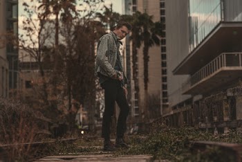 Man Standing on Pathway With Plants