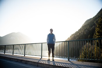 Man Standing on Road Beside Railings