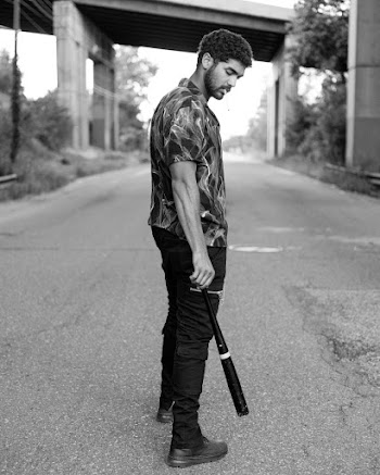 Man Standing on Road While Holding a Baseball Bat