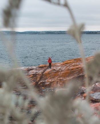 Man Standing on Rock Near Body of Water