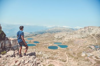 man standing on rocks looking down